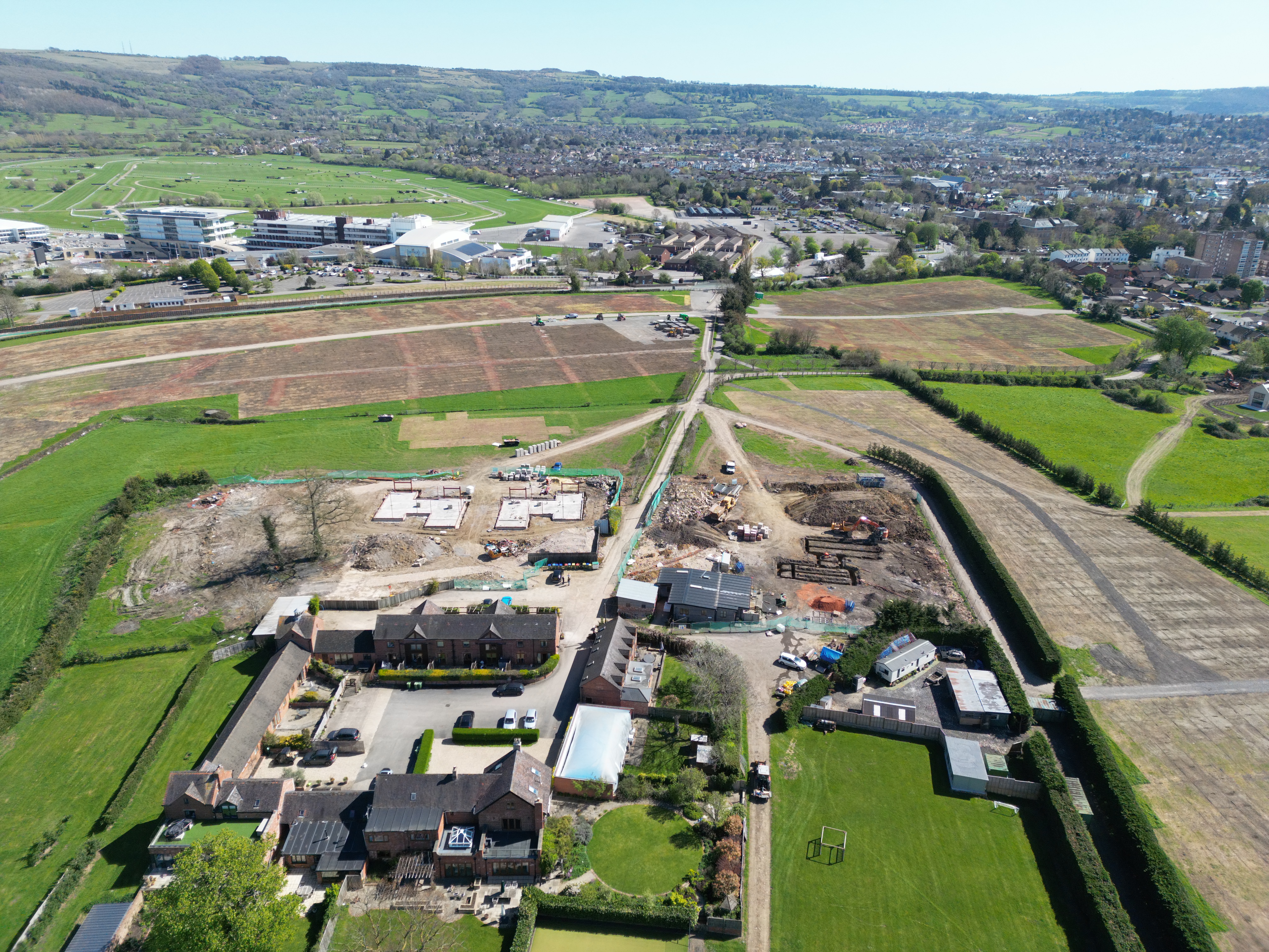 Aerial view of Prestbury, Cheltenham Racecourse and the Cotswold escarpment beyond